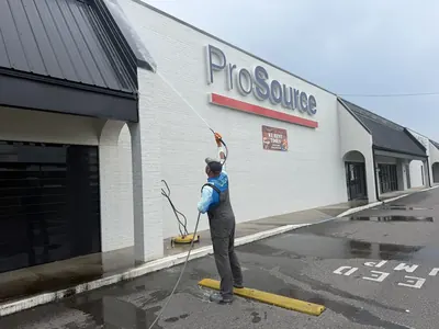 ProWash360 tech pressure washing the front of a commercial building