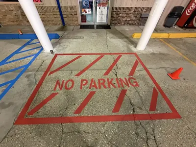 Freshly painted red no-parking zone and blue ADA striping at a store entrance