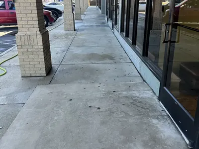 Covered sidewalk in front of a shopping center after pressure washing