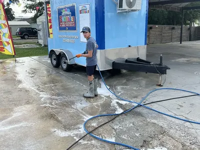 ProWash360 tech pressure washing a concession trailer and the pad around it